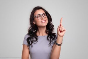 Campaña de Renta 2024. Fecha comienzo. Obligación y novedades. 1 Mujer guapa con gafas apuntando hacia arriba con fondo